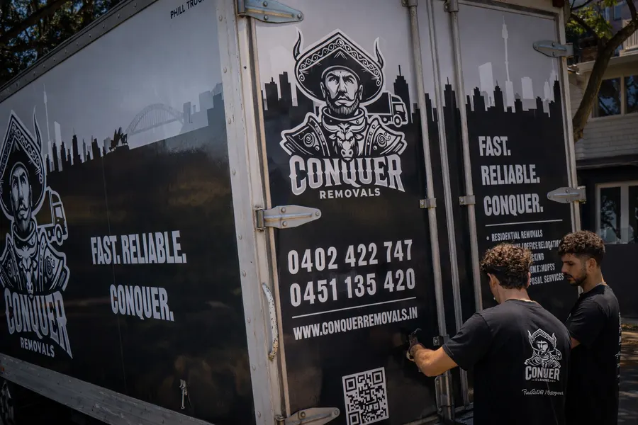 Conquer Removals crew branding the side of their moving truck