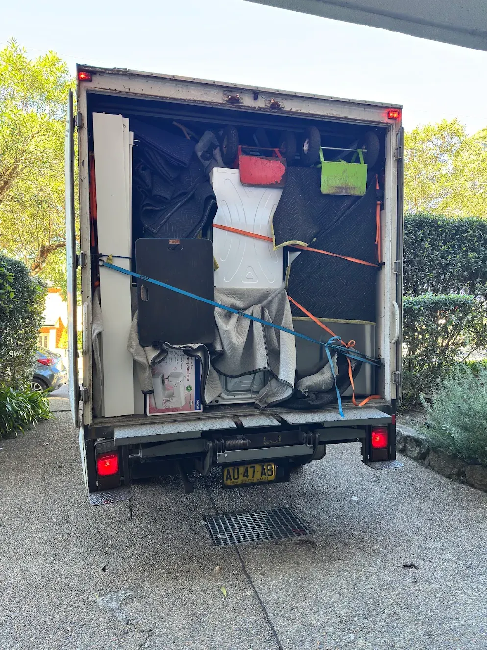 Boxes and appliances carefully packed and strapped into a Conquer Removals truck